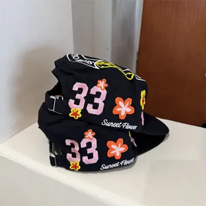 Chapeau pillbox noir avec broderie florale colorée et détail numéro 33