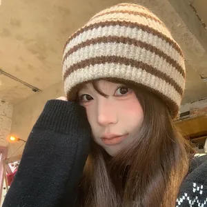 Fashionable vintage striped knit beanie for women shown in a cozy indoor cafe setting