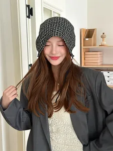 Detail of a Korean style plaid tie-up beanie worn by a model in a casual setting.
