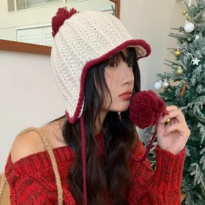 Cute knitted earflap hat with pom-poms in white and red for autumn and winter outfit