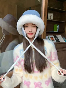Close-up detail of a warm blue plush winter bucket hat with stylish long ear protection straps