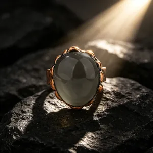 Primer plano de anillo de bronce vintage con piedra de cristal de té sobre roca oscura rugosa