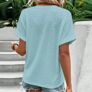 Back view of a light blue textured short-sleeve women's casual T-shirt in outdoor setting.