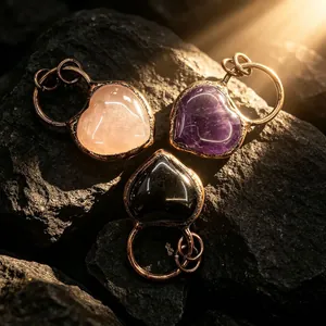 Gros plan de pendentifs en pierres fines en forme de cœur sur des rochers sombres
