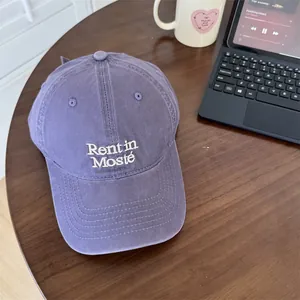 Casquette de baseball violette minimaliste avec broderie de lettres blanches sur bureau