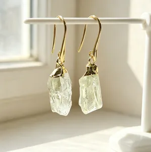 Macro detail of natural raw lemon quartz drop earrings with elegant gold-plated finish