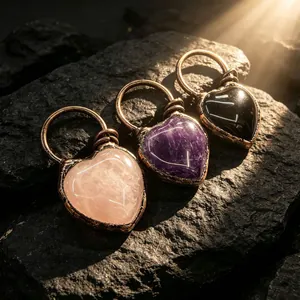 Gros plan de pendentifs cœur bohème en quartz rose, améthyste et agate noire entourés de bronze