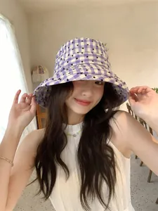Close-up detail of purple checkered bucket hat with heart print and sun protection brim