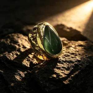 Detailansicht eines goldfarbenen Rings mit gehämmerter Textur und grünem Edelstein