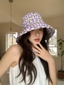 Stylish purple checkered sun bucket hat with heart pattern shown on a female model