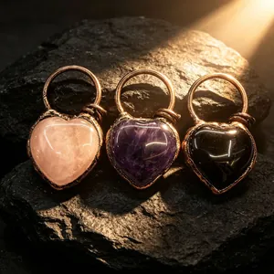 Détail de pendentifs en forme de cœur en quartz rose, améthyste et onyx enveloppés de fil