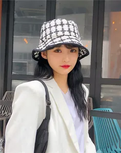 Detail shot showing the texture of a vintage black and white plaid wool bucket hat on a model