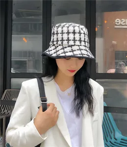 Detailed view of a vintage black and white plaid knit bucket hat worn by a model