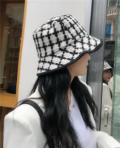 Detail of a retro black and white plaid bucket hat for women in a chic winter style.