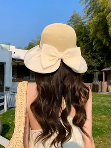 Back view of a French vintage wide brim straw hat with a large cream organza bow