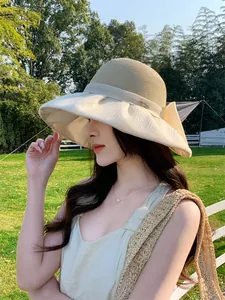 Detailed side view of an elegant Hepburn style straw hat with an organza bow and wide brim