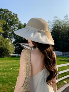 Elegant Hepburn style straw hat with large organza bow and wide brim for sun protection