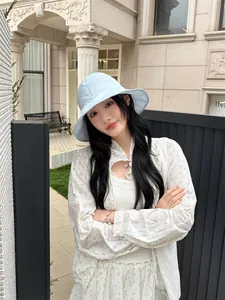 Stylish light blue wide-brim fisherman sun hat for women in outdoor street setting