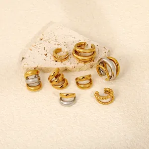 Detailed close-up of various gold and silver stainless steel C-shape ear cuffs