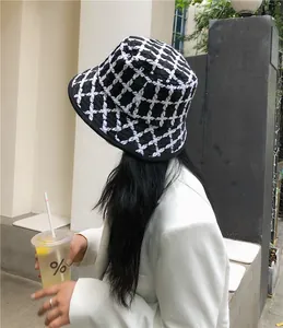 Detailed view of a retro black and white checkered knit bucket hat for women's winter fashion