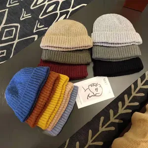 Detailed view of various colored knit beanies showcasing thick texture and warm wool