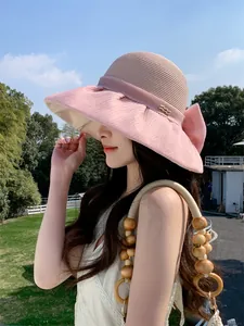 Detail side view of woman in pink organza bow straw hat for elegant summer sun protection
