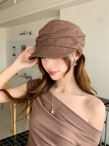 Gros plan d'une casquette gavroche en lin marron plissée portée par un mannequin