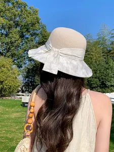 Vue arrière d'une femme portant un chapeau de soleil en paille à large bord