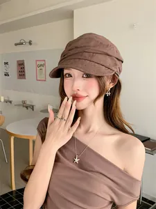 Gros plan d'une casquette en lin plissé marron portée par un mannequin au café