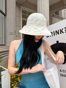 Close-up of woman wearing a stylish white wide-brim sun hat for outdoor sun protection