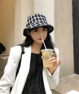 Close-up of a stylish retro black and white plaid bucket hat worn by a woman for autumn