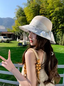 Femme asiatique élégante portant un chapeau de paille à large bord dans un jardin