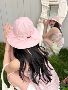 Back view of pink bucket sun hat with adjustable drawstring and mirror reflection detail