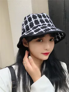 Model wearing a stylish black and white checkered retro bucket hat for autumn and winter.