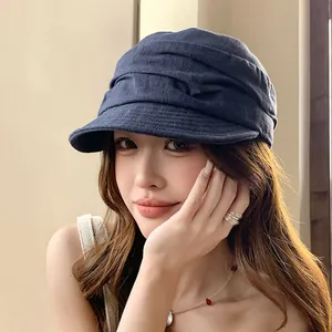 Chapeau équestre élégant en lin plissé bleu marine porté par un mannequin féminin