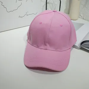 Detail of pink cotton twill baseball cap showing fabric texture and brim stitching