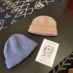 Close-up detail of knitted beanies in blue and pink showing ribbed texture and soft fabric