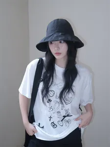 Stylish woman wearing a black sun protection bucket hat with a wide brim for outdoor use.