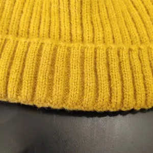 Close-up macro view showing the yellow ribbed knit texture and soft fabric of this winter beanie