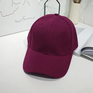Detail view of a classic burgundy solid color baseball cap in a minimalist setting