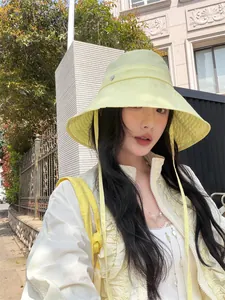 Asiatisches Model mit hellgelbem Anglerhut mit breiter Krempe für Sonnenschutz