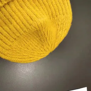 Macro view of the bright yellow knitted wool beanie showing detailed stitch pattern