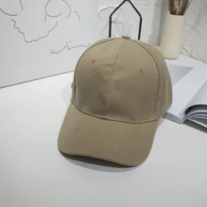 Minimalist khaki cotton baseball cap displayed on a white aesthetic desk setup.