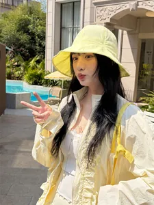 Outdoor lifestyle view of a woman wearing a yellow sun protection hat and jacket