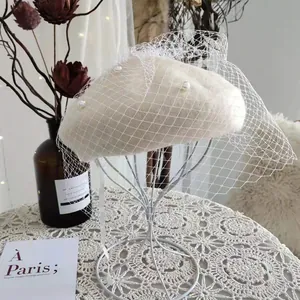 Detail view of wool beret with elegant pearls and decorative mesh veil