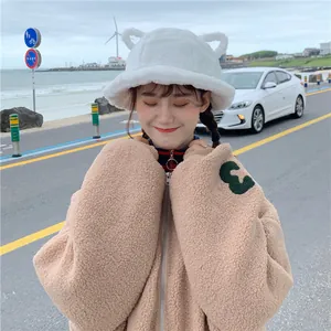 Cute white plush bucket hat with cat ears shown on model outdoors