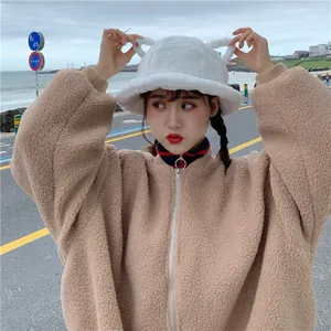 Close-up of a cute white plush bucket hat with bear ears on an Asian model outdoors