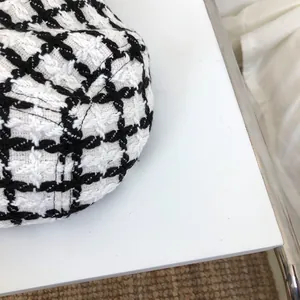 Close-up of black and white checkered knit fabric on a stylish bucket hat detail view.