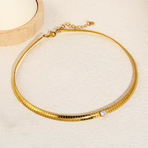 Detailed view of a gold-plated blade chain necklace with a single round white crystal