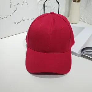Close-up of a solid red baseball cap with cotton twill texture in lifestyle setting
